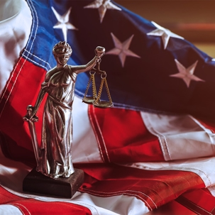 Justice statue and american flag
